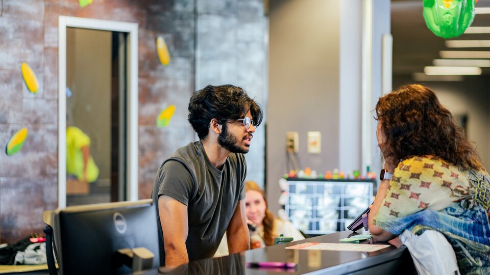 Desk Assistant helping student