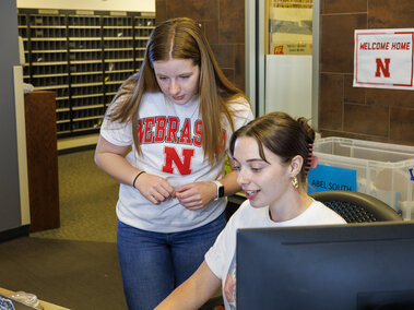 Two student employees at a residence hall front desk